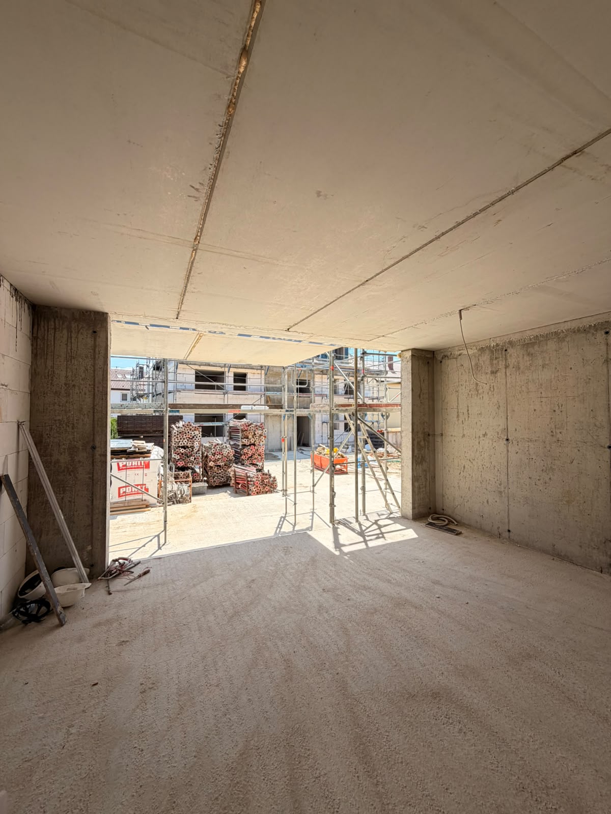 Innenraum im Rohbau mit großer Fensteröffnung Richtung Hof