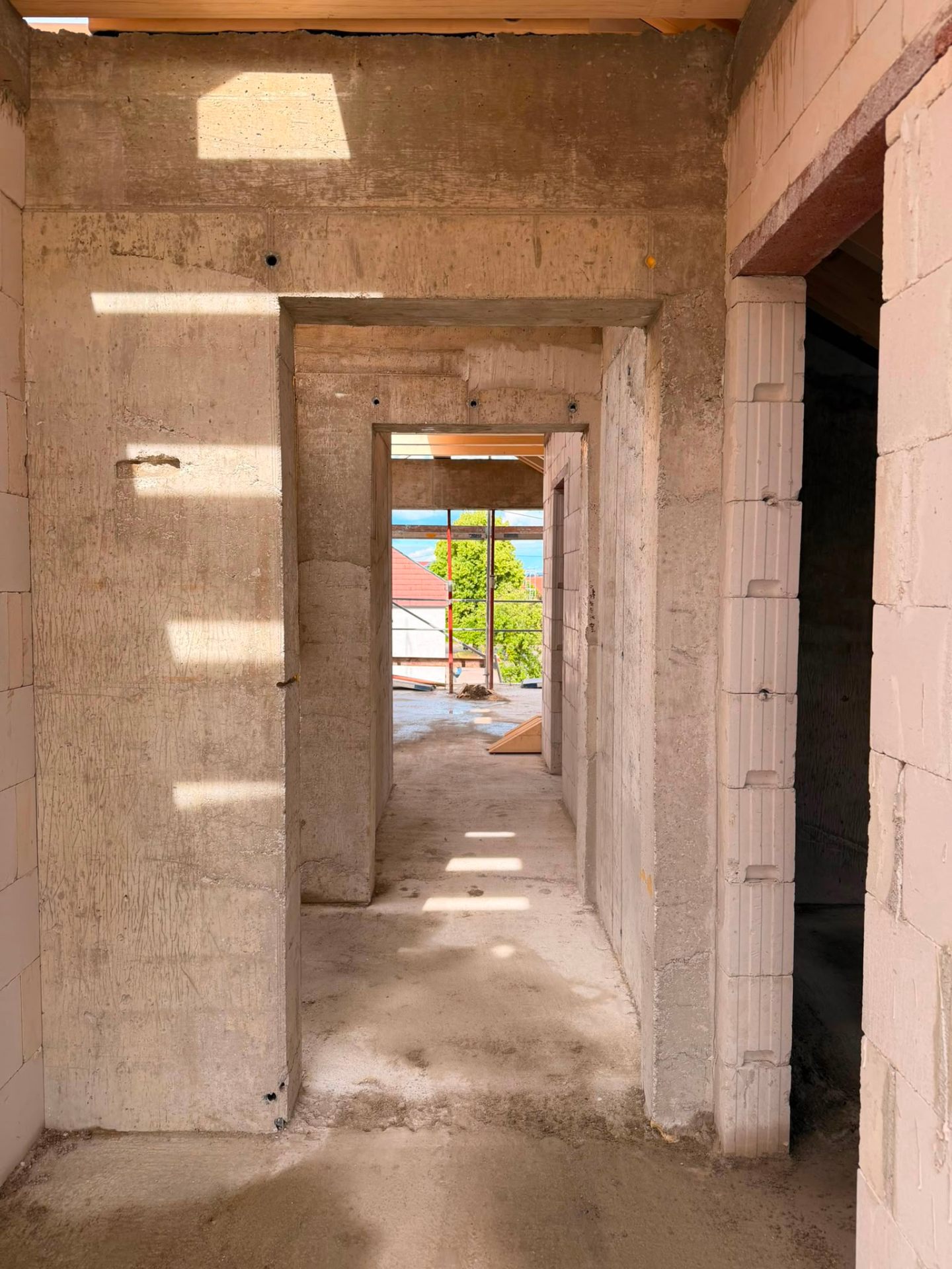 Flur im Rohbau mit Sichtbeton und Türöffnungen